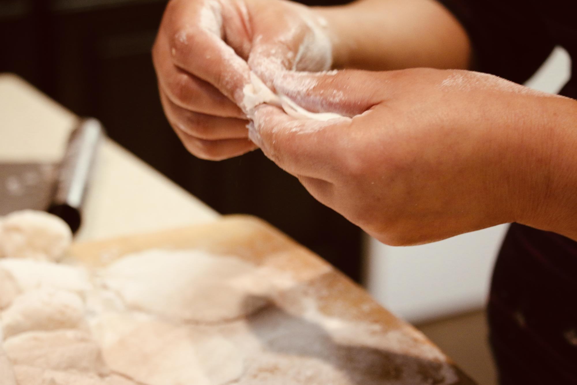 Close-up hands kneading dough